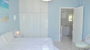 A bedroom with a bed, a nightstand, a wardrobe, and a chair. - Holiday Beach House Ritsa am Agios Gordios, Corfu (Corfu)