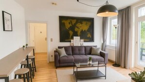 A modern living room with a sofa, coffee table, and a world map on the wall. - The World Appartment (Magdeburg)