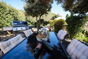 Enjoy al fresco dining in a serene garden setting, complete with a grill for outdoor cooking.