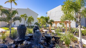 Ein angelegter Garten mit mehreren Wasserspielen und Palmen.