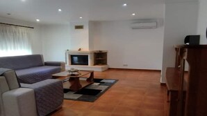 A living room with a sofa, a coffee table, and a fireplace. - Casa Rural Muito Tranquila (Ortigosa de Cima)