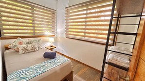 A bedroom with a bed, two bedside tables, a lamp, and a wooden wardrobe. - Villa Ocean Coral Luxury Beachfront Villa just steps away from the beach! (Punta Uva)
