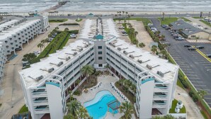 Et hotel med pool, havudsigt og parkeringsplads.