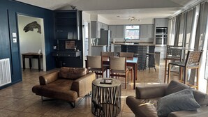 A modern living room with leather sofas, a coffee table, and a dining area with chairs and a small table. - Stylish, dog friendly, recently renovated home <3 miles from Texas A&M. 
 (Bryan)