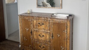 A wooden cabinet with multiple drawers and a mirror above it, placed against a white wall. - Stylish, dog friendly, recently renovated home <3 miles from Texas A&M. 
 (Bryan)