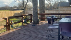 A wooden deck with outdoor furniture, including a table and chairs, and a barbecue grill. - Stylish, dog friendly, recently renovated home <3 miles from Texas A&M. 
 (Bryan)
