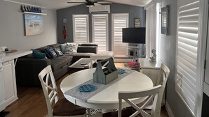 Un espacio habitable compacto con comedor, ventilador de techo y televisor de pantalla plana.