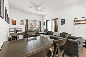 A modern living room with a dining table, sofas, and a ceiling fan. - Beautiful Florida Condo  (Kissimmee)