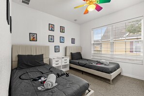 A bedroom with two beds, a ceiling fan, and a window with blinds. - Beautiful Florida Condo  (Kissimmee)