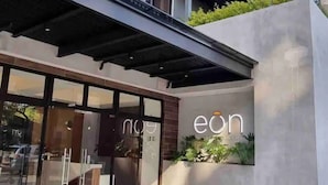 A modern building with a glass entrance, a visible logo, and a concrete structure.