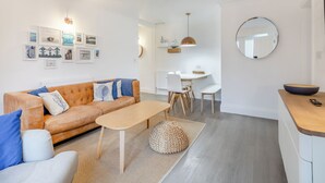 Uma sala de estar moderna com sofá, mesa de centro e área de jantar.