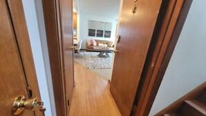 Un escalier en bois mène à un salon où se trouvent un canapé et une table basse.