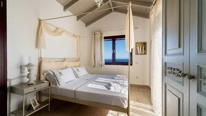 Une chambre à coucher avec un lit à baldaquin, une table de chevet avec une lampe et une fenêtre avec des rideaux.