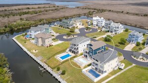 A residential area with houses, a dock, and a lake. - Waterfront,Pool,Game Room,Beach,DeepWaterAccess (Manteo)