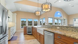 A modern kitchen with granite countertops, stainless steel appliances, and wooden cabinets. - Waterfront,Pool,Game Room,Beach,DeepWaterAccess (Manteo)