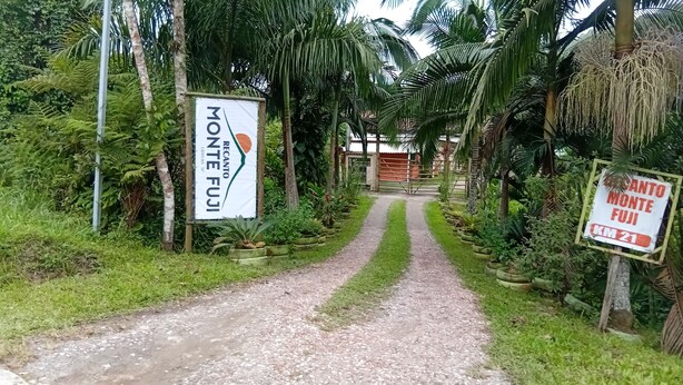 Ein Weg führt zu einem befriedeten Bereich mit Schildern, auf denen 'Monte Fuji' und 'KM 21' stehen.