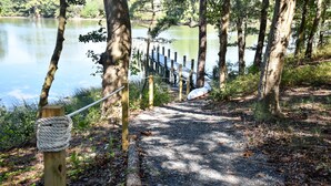 A gravel path leading to a wooden dock by a calm lake, surrounded by trees. - Pet-Friendly Waterfront Retreat w/ Private Dock on Virginia’s Eastern Shore (Exmore)