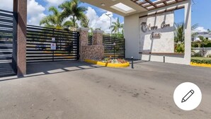 Une entrée fermée par un portail, sur laquelle est apposée une plaque indiquant : « Domaine de Happy Cove ».