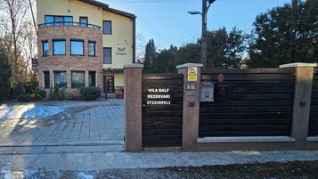 Una entrada cerrada a un edificio con fachada de piedra y múltiples ventanas.