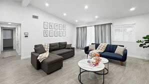 A modern living room with a sectional sofa, a smaller sofa, and a coffee table.