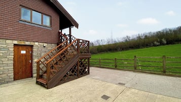 Un bâtiment doté d’un escalier en bois menant à un porche abrité.