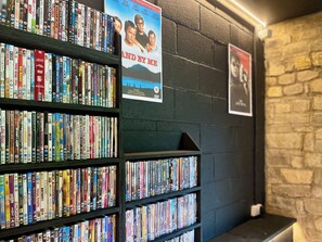 Une bibliothèque avec de nombreuses étagères remplies de DVD et de livres.