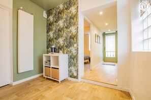 Cozy retreat with a green accent wall, white radiator, and shelving unit.