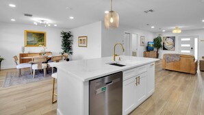 A modern kitchen with a central island, white cabinetry, and stainless steel appliances. - Gorgeous St. Johns River home 3bdrm/2 bth (Osteen)