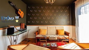 A cozy living room with a sofa, armchairs, a glass coffee table, and a wall-mounted guitar. - Near KYSHP & Fasig-Tipton
Equestrian & Bourbon Tours Central
The Kingston!! (Lexington)
