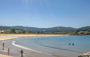 A beach with clear skies, gentle waves, and a hilly landscape in the background. - Cozy apartment in O Porto de Espasante (O Porto de Espasante)