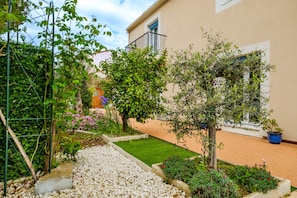 Un giardino con diverse piante e una piccola zona verde.
