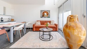 A modern living room with a sofa, coffee table, and a large vase. - Villa 'Venza , Salento' with Sea View, Wi-Fi and Air Conditioning (Otranto)