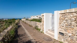A coastal pathway leading to a modern building with a stone wall and a clear view of the sea. - Villa 'Venza , Salento' with Sea View, Wi-Fi and Air Conditioning (Otranto)