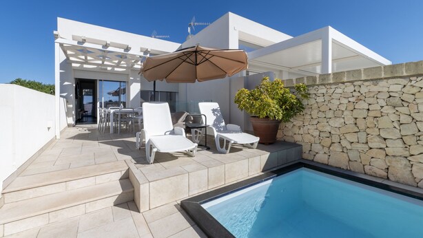 A modern outdoor pool area with lounge chairs, a pergola, and a stone wall. - Villa 'Venza , Salento' with Sea View, Wi-Fi and Air Conditioning (Otranto)