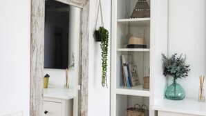 A white shelf with a rustic mirror, a hanging plant, a decorative cone, and a vase with greenery. - Villa 'Casa Ohana' with sea views, Wi-Fi, and air conditioning (Fuengirola)