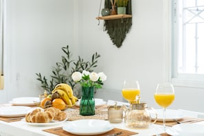 A breakfast table with croissants, fruit, a vase with flowers, and two glasses of orange juice. - Villa 'Casa Ohana' with sea views, Wi-Fi, and air conditioning (Fuengirola)