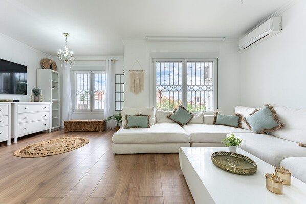 A modern living room with a sofa, a coffee table, and a TV.