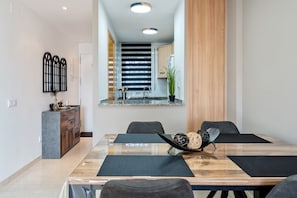 Een moderne eetruimte met een houten tafel, zwarte stoelen en een decoratief middelpunt.