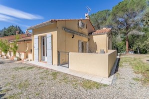 A two-story building with a tiled roof, a small balcony, and a gravel driveway. - Holiday Home 1 with Mountain View, Air Conditioning (Reynes)