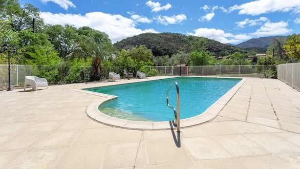 A swimming pool with a metal ladder, surrounded by a tiled deck and chairs, with a mountainous backdrop. - Holiday Home 4 with Mountain View, Shared Pool (Reynes)