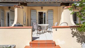 A patio with a table and chairs, a small garden, and a door leading to the interior. - Holiday Home 4 with Mountain View, Shared Pool (Reynes)