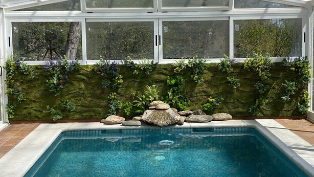 A swimming pool with a glass ceiling, surrounded by a wall with greenery and rocks. - Large family country house in Rascafría,1 h from Madrid, 12 to 24 people (Rascafría)