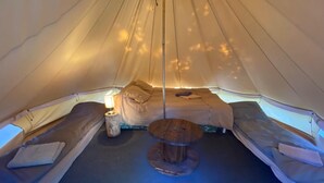 A cozy tent interior with a central table, two sleeping areas, and a small lamp. - Large family country house in Rascafría,1 h from Madrid, 12 to 24 people (Rascafría)