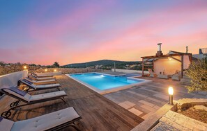 A rooftop pool area with lounge chairs and a pergola with a chimney, overlooking a hillside. - Cozy home in Dvornice (Dvornice)