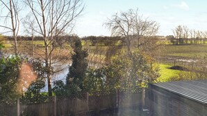 A rural landscape with a wooden fence, trees, and a field. - 4 bedroom accommodation in Boston (Boston)