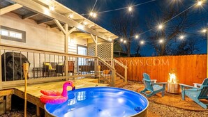 A backyard with a hot tub, outdoor seating, and a wooden deck. - Southtown 3BR Pool & Playset—Riverwalk—BBQ—Firepit (San Antonio)