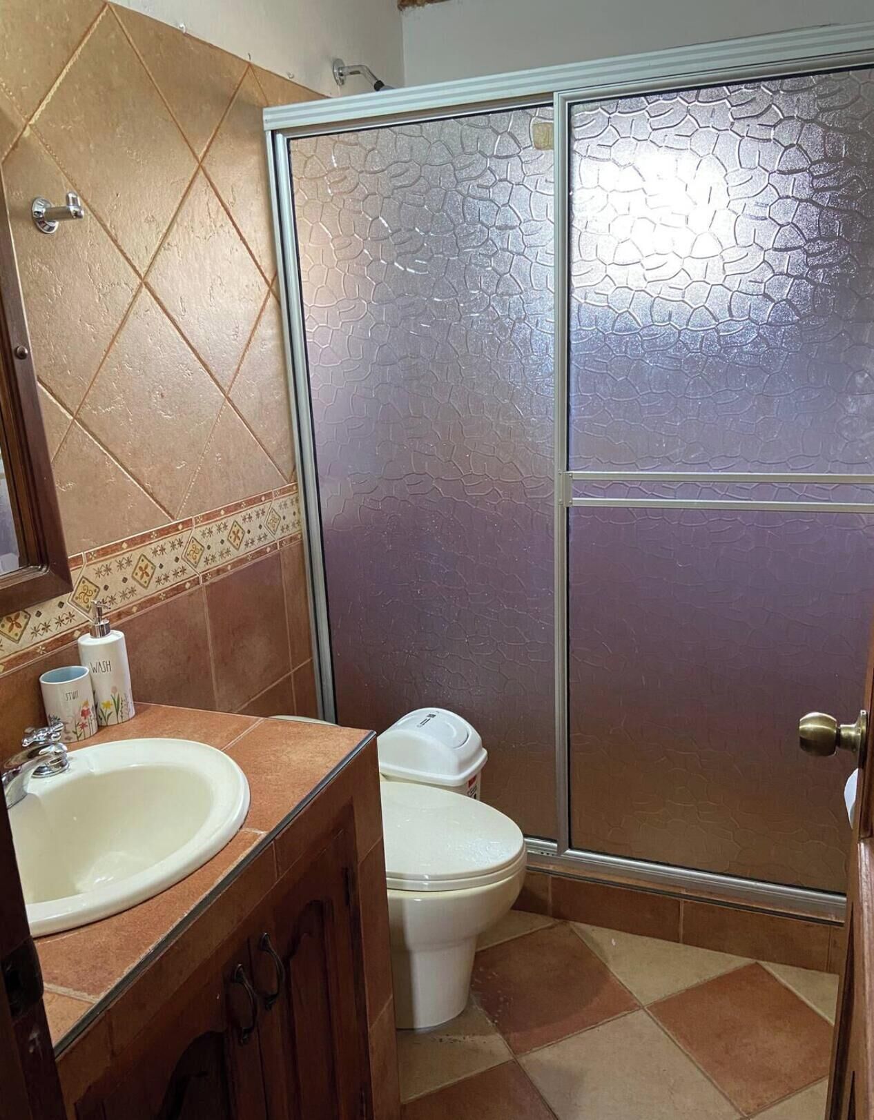 Ein Badezimmer mit Waschbecken, Toilette und Duschbereich.