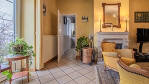 Una sala de estar con chimenea, televisor y comedor con mesa y sillas.