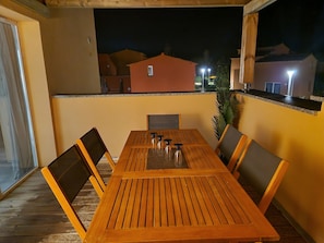 Enjoy dining or socializing in this inviting patio area with a table and chairs.