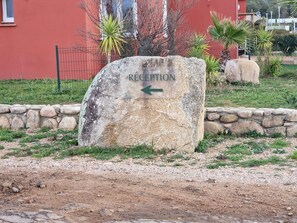 Welcome to the entrance of our hotel, marked by a historic stone sign pointing to the reception area.